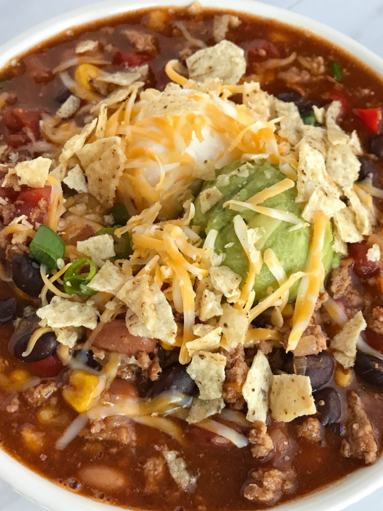 Southwestern Turkey Chili Taco Soup | Turkey chili taco soup loaded with all the best southwest flavors. Turkey taco meat, chili beans & spices, corn, tomato, and taco soup seasonings all combine for one deliciously hearty chili taco soup. It's the best of both worlds. Top with cheese, sour cream, guacamole, and crushed tortilla chips | www.togetherasfamily.com #tacosoup #chilirecipe #turkeychili #dinnerrecipes