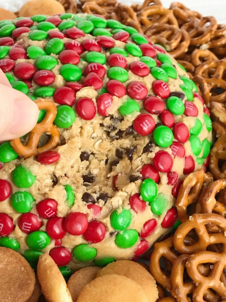 Christmas Cookie Dough Cheeseball Dip | Cookie dough cheeseball dip is the best appetizer or snack to take to a party or munch on during the Holidays! Red and green m&m's cover the outside of a peanut butter oatmeal chocolate chip cookie dough cheese ball. No flour and no eggs so it's perfectly safe to eat. Serve with pretzels, wafers, cookies, and anything else | www.togetherasfamily.com #christmascookies #appetizerrecipes