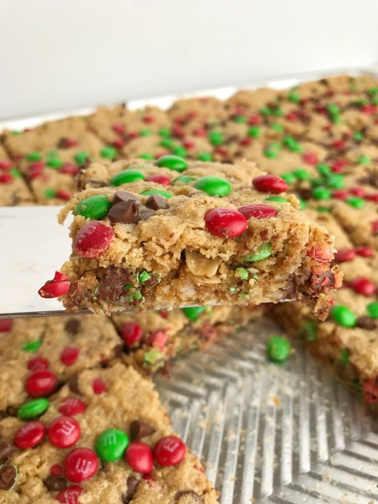 No Flour Monster Cookie Bars | Celebrate the holidays and make Santa's favorite Christmas cookie bars! No flour Christmas cookie bars are loaded with oats, peanut butter, chocolate, and festive green & red mini m&m's. Thick, chewy bars that everyone loves and they only take minutes to make | www.togetherasfamily.com #christmascookies #noflourdesserts #monstercookiebars #noflourbars #cookiebarrecipes #christmasrecipes #christmascookierecipes
