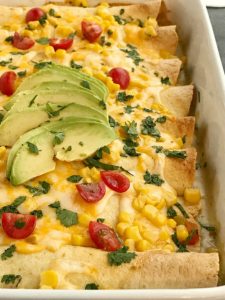 Green Chili Corn Enchiladas | Enchilada Recipes | Chicken Recipes | Mexican Food | Easy Dinner Recipes | Green chili chicken corn enchiladas are an easy family dinner that can be on the table in almost 30 minutes! Use leftover chicken or a rotisserie chicken, canned corn, cheese, and green chili enchilada sauce. Easy and simple ingredients for a delicious dinner recipe #dinnerrecipes #easyrecipes #enchiladarecipes