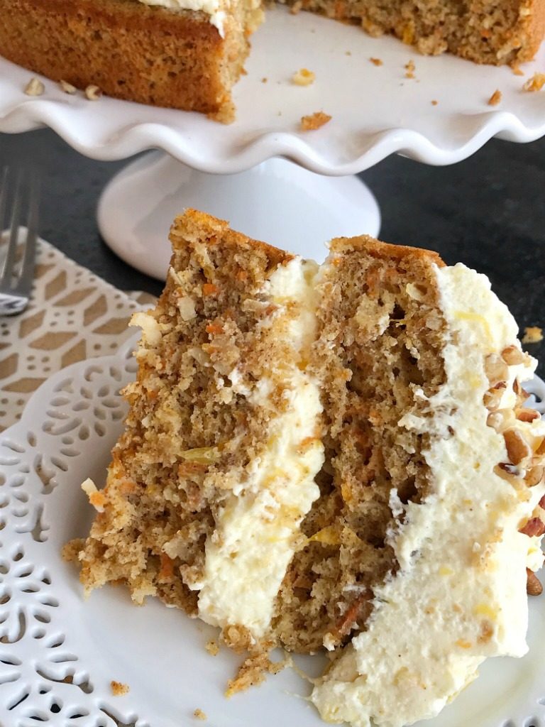 Tropical Layered Carrot Cake w/ Pineapple Pudding Frosting | Try this tropical layered carrot cake for a fun and delicious twist to traditional carrot cake. Carrot cake starts with a boxed cake mix, fresh grated carrots, mandarin oranges and is topped with an incredibly light & fluffy pineapple pudding frosting. Tropical layered carrot cake is just like the famous pig pickin' cake but with a carrot cake twist #easterdesserts #easterrecipes #carrotcake #carrotcakerecipes