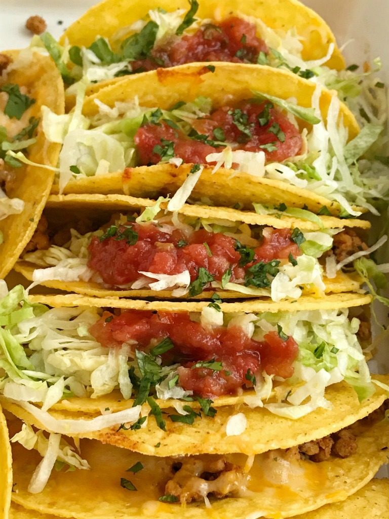 Baked Ground Chicken Tacos | Tacos | Mexican recipes | recipes with ground chicken | Baked ground chicken tacos are an easy, 30 minute dinner recipe! Crispy corn taco shells are filled with tender and flavorful ground chicken with homemade taco seasoning. So much flavor and healthy too! Load up the cheesy crispy tacos with all your favorite toppings #tacos #easydinnerrecipes #dinner #groundchicken #mexicanfood 