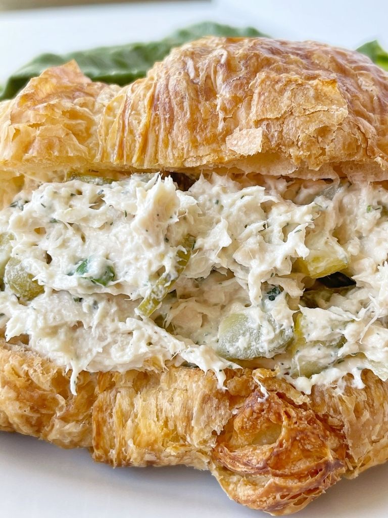 Dill pickle chicken salad inside a croissant roll that's cut in half. 