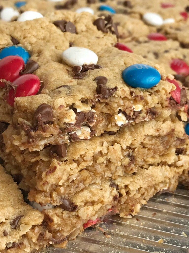 No Flour Red, White, & Blue Cookie Bars | No Flour Desserts | Gluten Free | Cookie Bars | Monster Cookies | Celebrate Memorial Day and 4of of July with these fun and festive no flour red, white, & blue cookie bars. Cookie bars with no flour and loaded with peanut butter, oats, chocolate chips, and m&m's. This holiday dessert recipe will be the hit of the BBQ. Makes an entire cookie sheet so there is plenty to serve a crowd. #glutenfree #4thofjuly #patriotic #easydessertrecipes