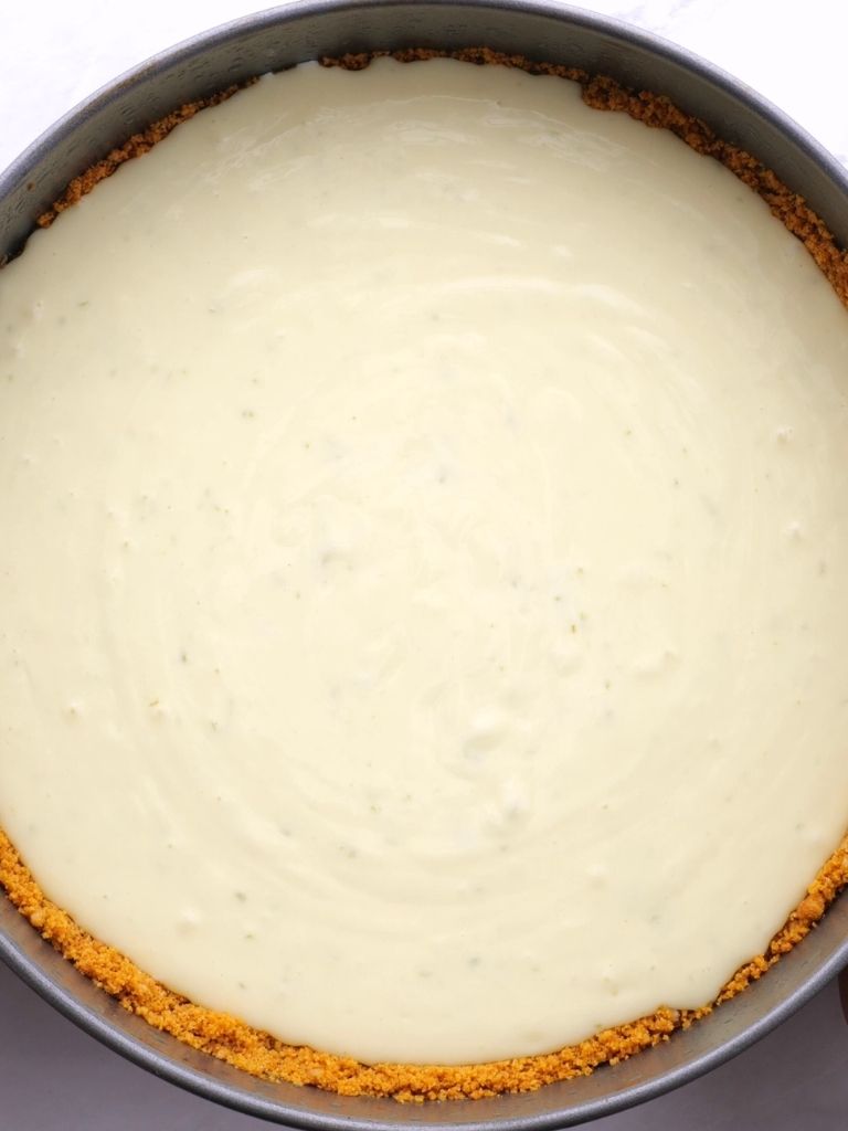 A springform pan with cheesecake mixture poured into it.