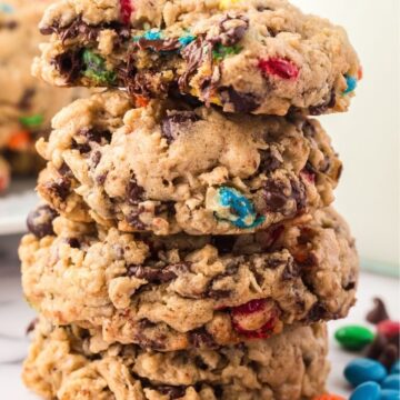 Stack of monster cookies with a bite taken out of the top cookie.