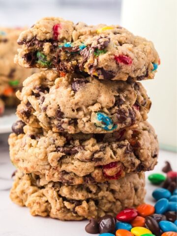Stack of monster cookies with a bite taken out of the top cookie.