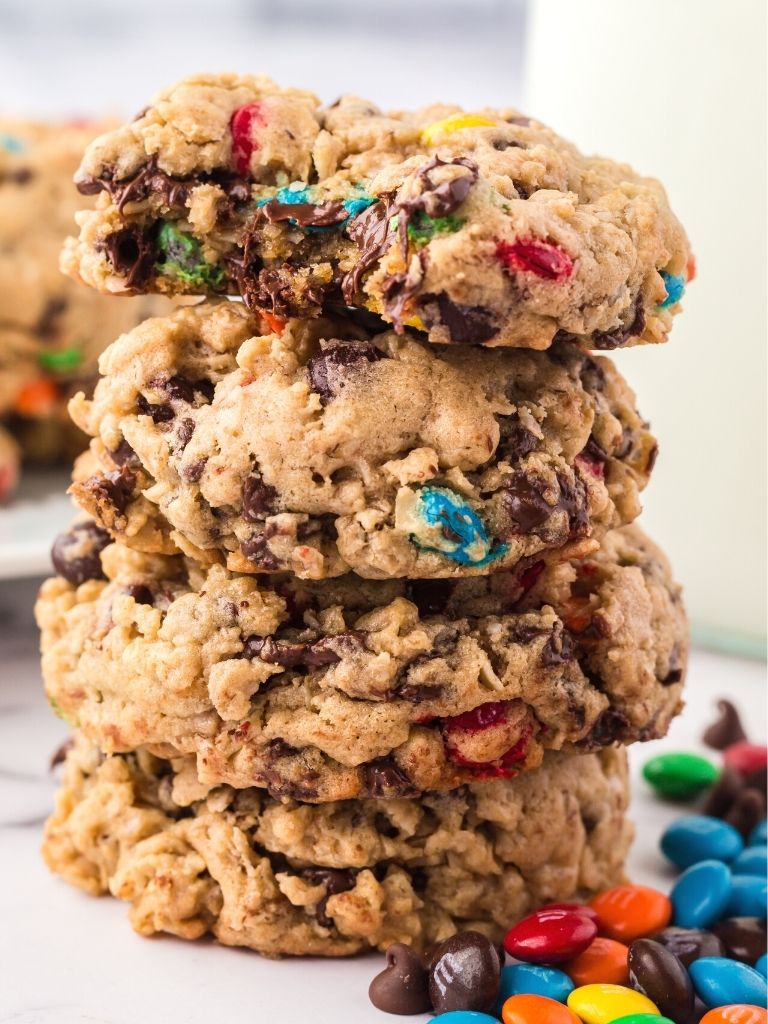 Stack of monster cookies with a bite taken out of the top cookie.