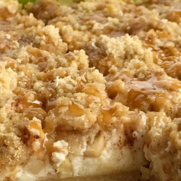 Caramel Apple Cheesecake Bars have a short bread crust, creamy cheesecake, cinnamon sugar apples, and a brown sugar oat crumble. Drizzle with caramel sauce for a delicious apple dessert recipe.