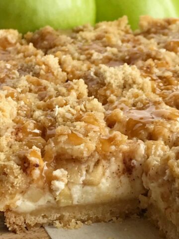 Caramel Apple Cheesecake Bars have a short bread crust, creamy cheesecake, cinnamon sugar apples, and a brown sugar oat crumble. Drizzle with caramel sauce for a delicious apple dessert recipe.