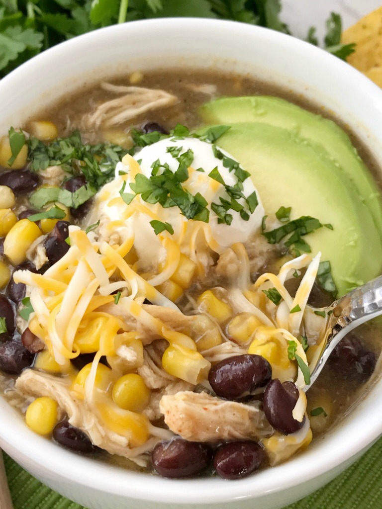 Chicken Enchilada Soup | Soup Recipe | Chicken Recipe | Chicken enchilada soup made in the slow cooker. Loaded with chicken, black beans, corn, that simmers in a green chili enchilada sauce and chicken broth in the crock pot. Serve with avocado, sour cream, cheese, and chips! 