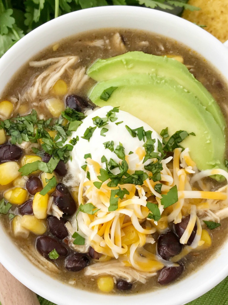 Chicken Enchilada Soup | Soup Recipe | Chicken Recipe | Chicken enchilada soup made in the slow cooker. Loaded with chicken, black beans, corn, that simmers in a green chili enchilada sauce and chicken broth in the crock pot. Serve with avocado, sour cream, cheese, and chips!