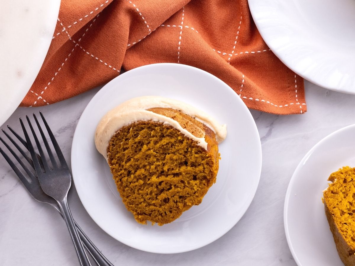 Pumpkin bundt cake slice on a plate with a fork. 
