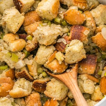 A pot of stuffing with a wooden spoon in it.