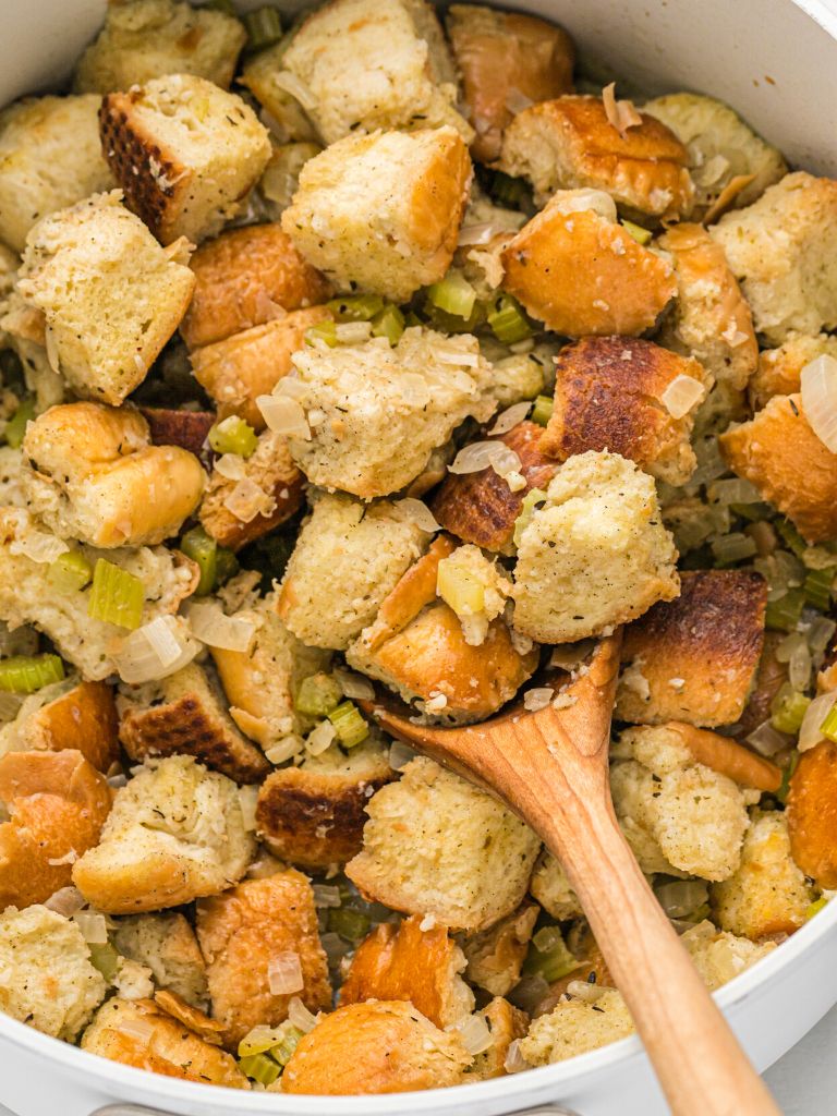 A pot of stuffing with a wooden spoon in it.