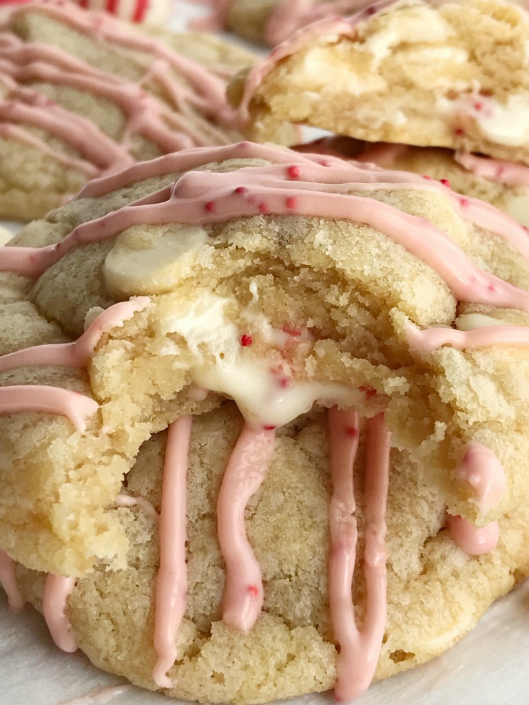 Soft baked white chocolate pudding peppermint cookies that are stuffed with a Hershey's candy cane kiss! These are the best Christmas cookies you'll ever have. Sweet, soft, thick, stuffed with a candy cane kiss, and drizzled with melted candy cane kisses.