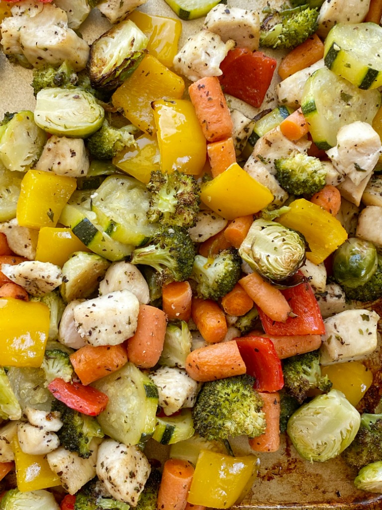 Baked Chicken and Vegetables roast in the oven on one sheet pan! Chicken breasts, bell peppers, Brussels sprouts, broccoli, carrots, and zucchini bake in seasoned olive oil.