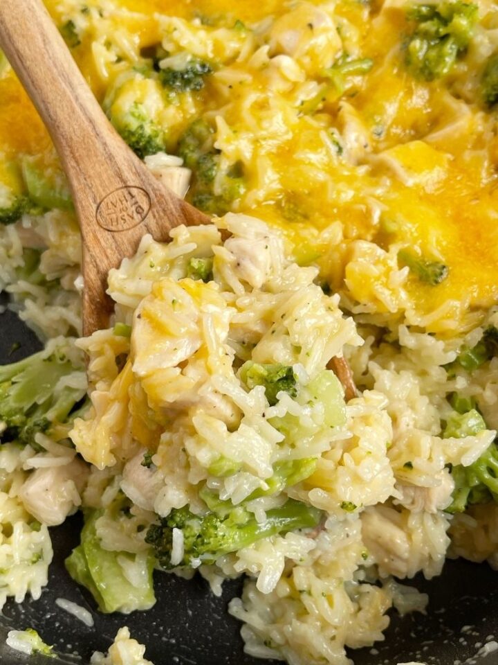 One scoop of chicken broccoli rice on a wooden spoon.