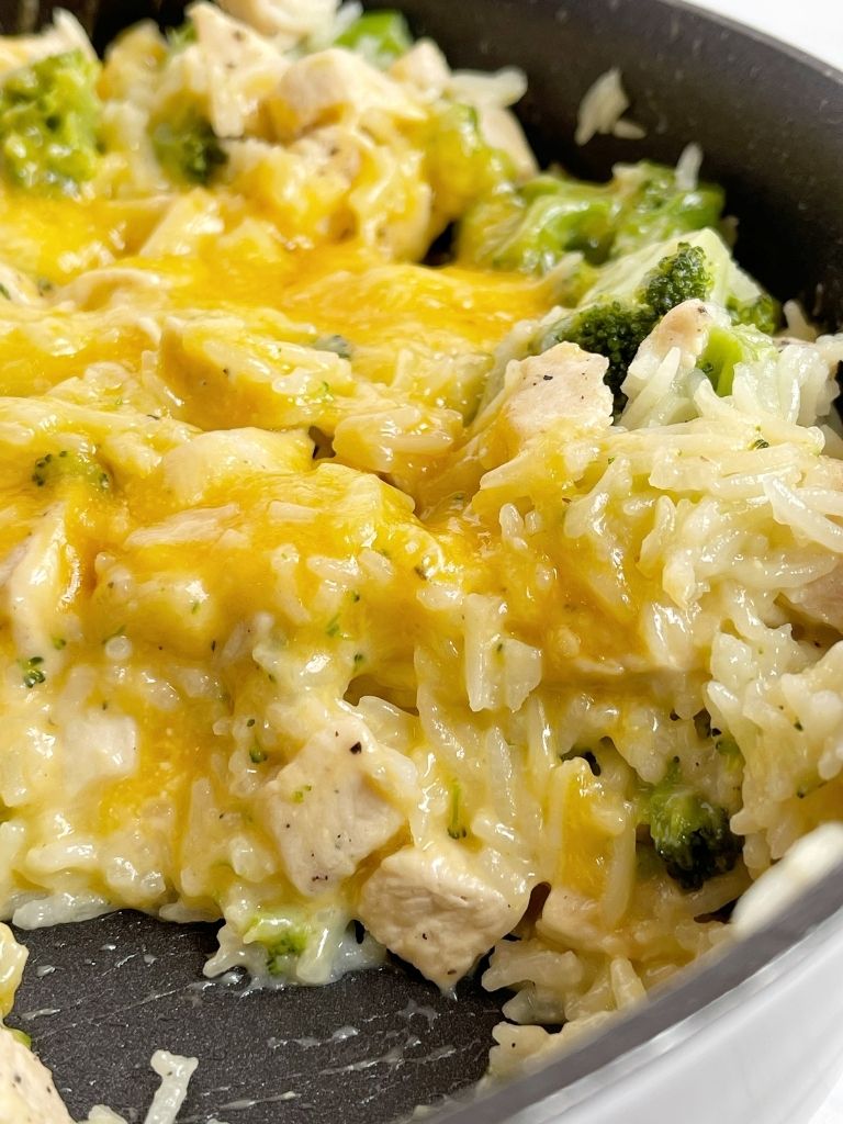 Close up of the cheesy rice and chicken inside a skillet pan.
