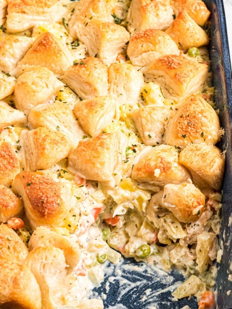 Creamy pot pie casserole inside a blue casserole dish with the corner dished out. 