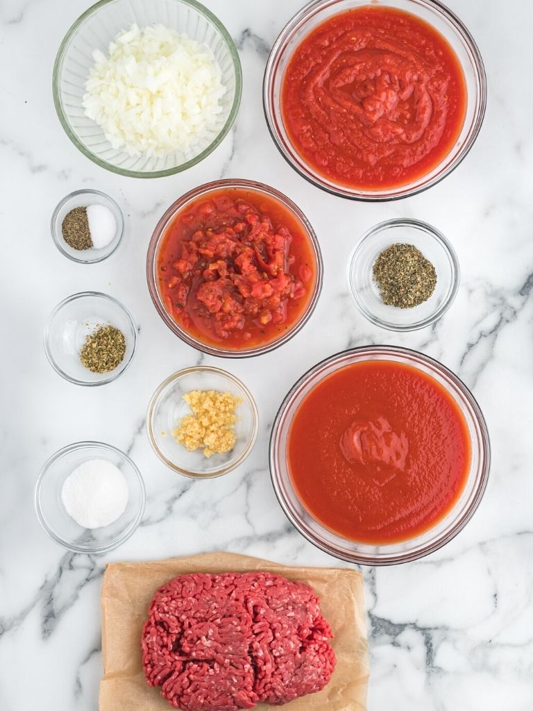 Ingredients needed to make spaghetti meat sauce. Each ingredient is inside it's own bowl. 
