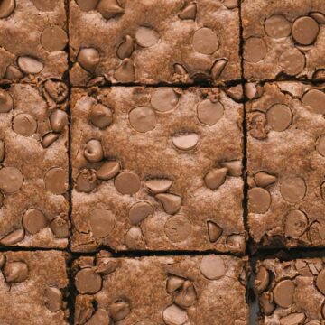 Overhead shot of a pan of brownies with milk chocolate chips on top.