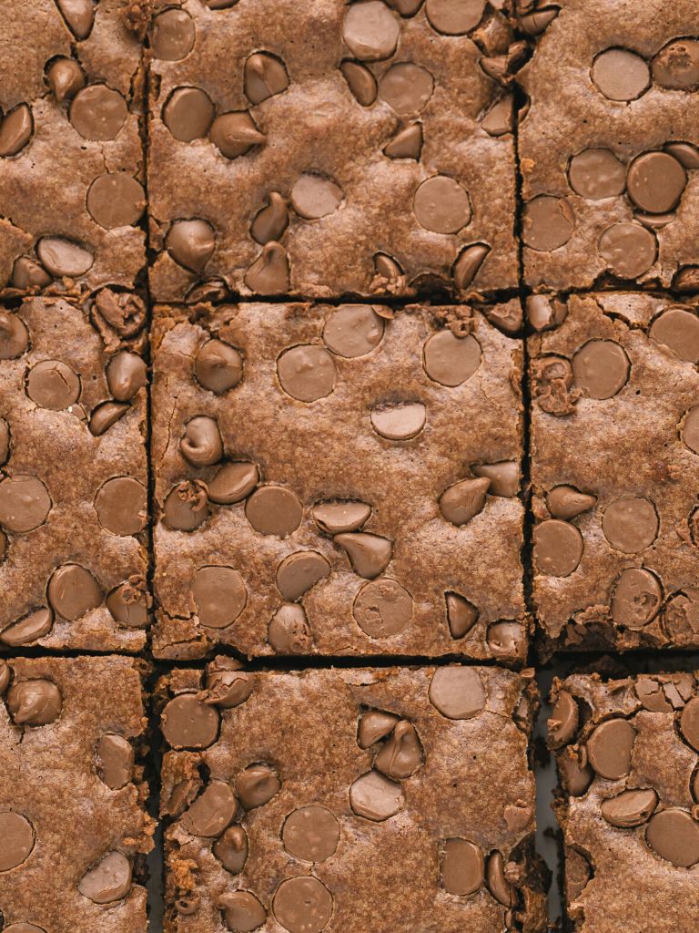 Overhead shot of a pan of brownies with milk chocolate chips on top. 