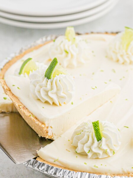 A no bake key lime with a pie tool holding a piece of it.
