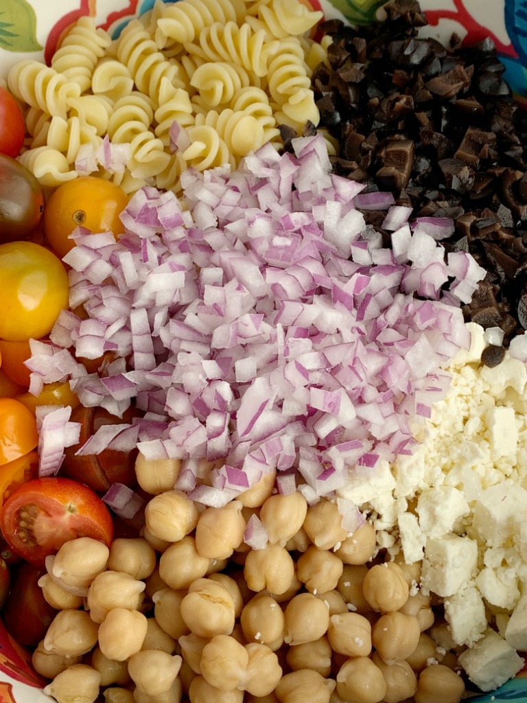 Greek Pasta Salad | Pasta Salad Recipes | Easy Greek Pasta Salad with tender spiral pasta, feta cheese, black olives, cherry tomatoes, red onion, and chickpeas with a easy dressing of Greek Vinaigrette salad dressing. So much flavor and texture, it's sure to be a hit. #salad #pastasalads #greek #sidedish #summerrecipes #pastasaladrecipes #recipeoftheday