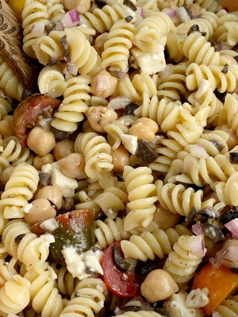 Greek Pasta Salad | Pasta Salad Recipes | Easy Greek Pasta Salad with tender spiral pasta, feta cheese, black olives, cherry tomatoes, red onion, and chickpeas with a easy dressing of Greek Vinaigrette salad dressing. So much flavor and texture, it's sure to be a hit. #salad #pastasalads #greek #sidedish #summerrecipes #pastasaladrecipes #recipeoftheday