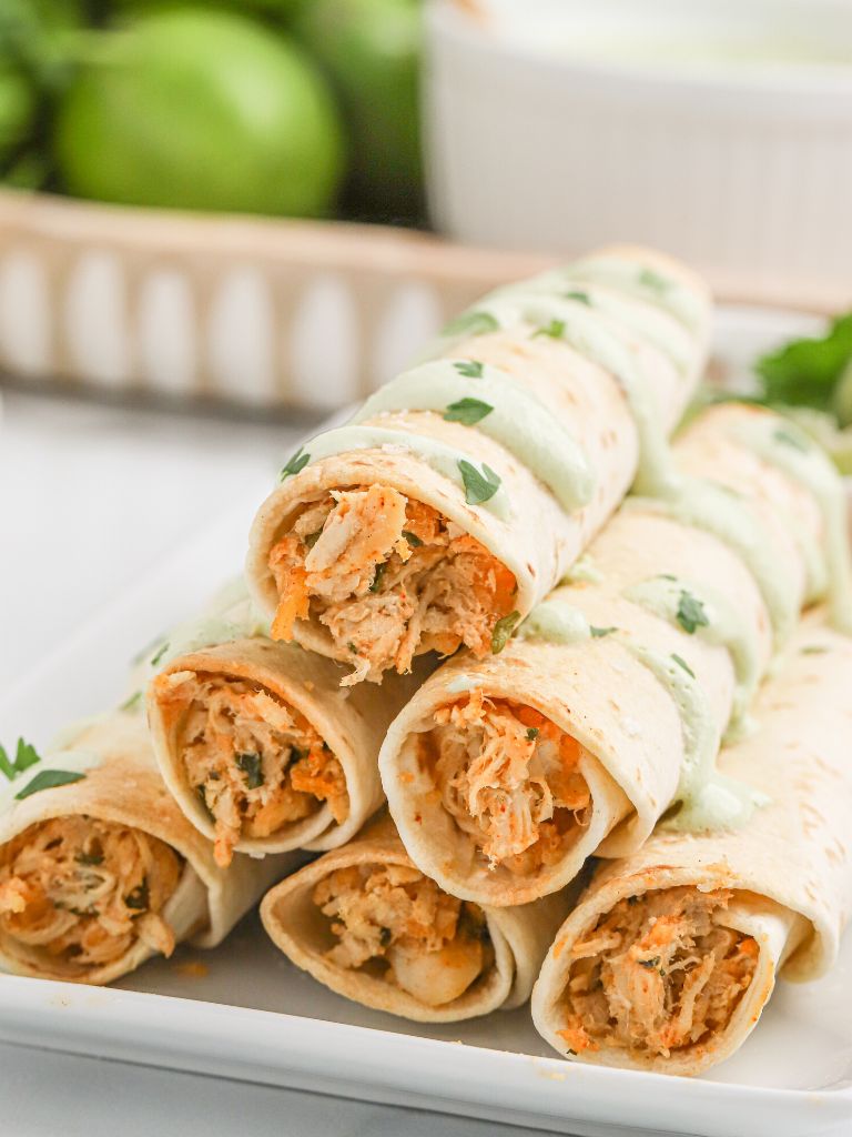Stack of flour taquitos with chicken filling inside of it. 