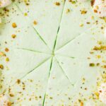 A no bake pistachio pie topped with whipped cream and pistachios.