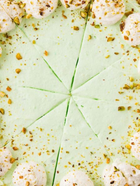 A no bake pistachio pie topped with whipped cream and pistachios.