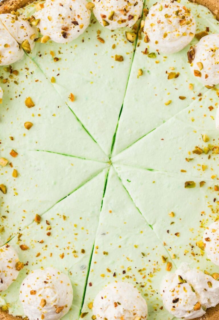 A no bake pistachio pie topped with whipped cream and pistachios.