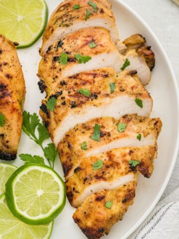 Sliced grilled chicken on a white plate