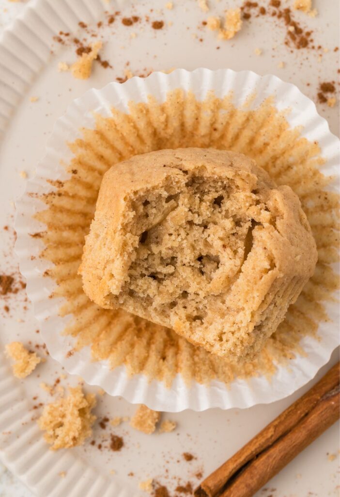 A muffin laying down with a bite taken out of it, to show the moist center.