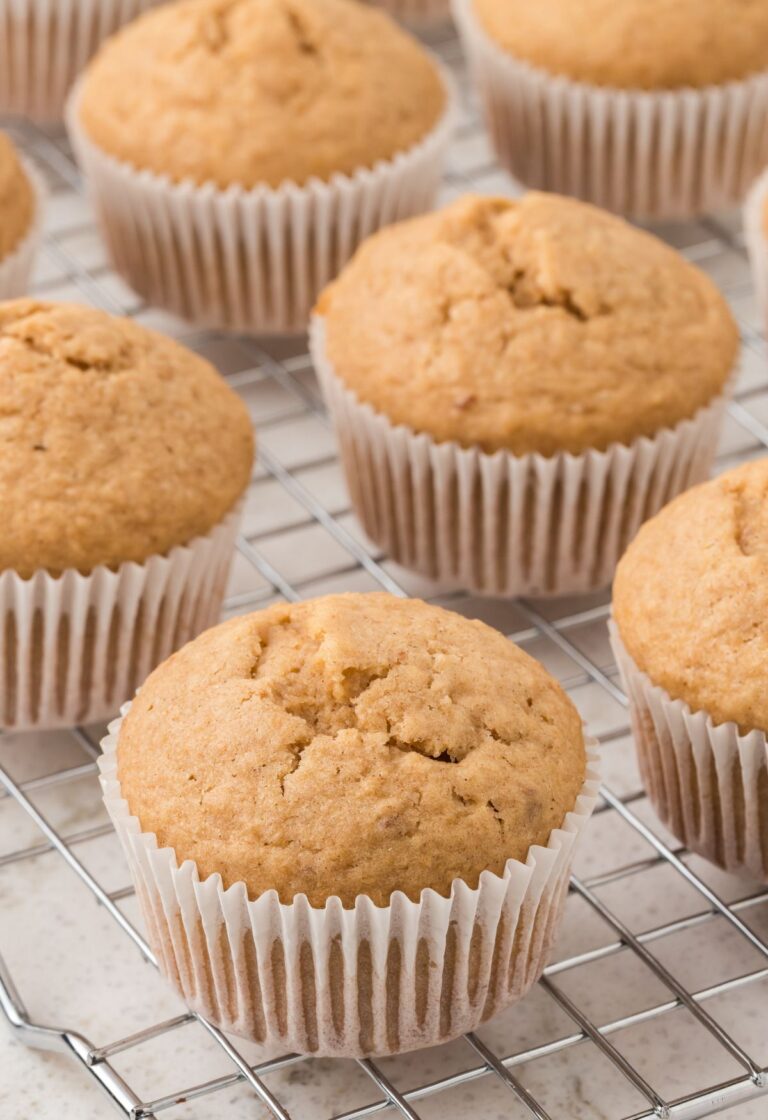 Cooling rack with the muffins inside wrappers on it.