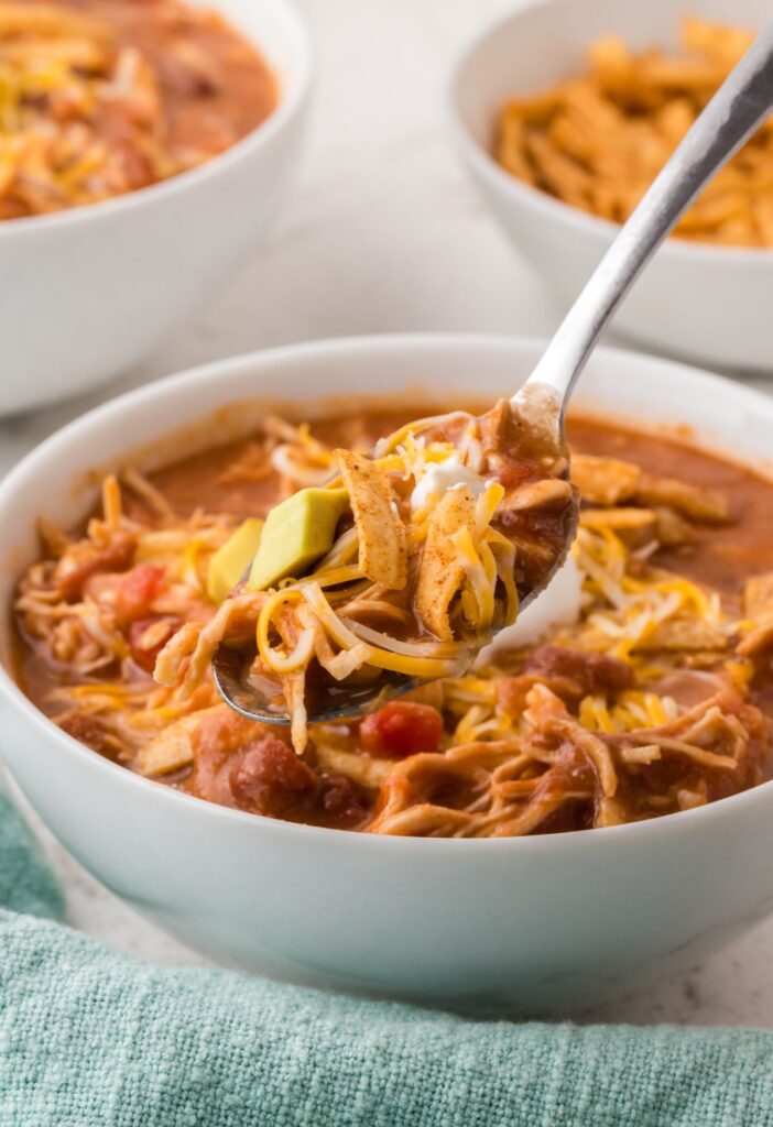 A bowl of soup with a spoon with some soup on it.