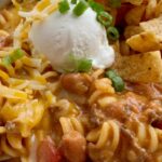 Ground Beef Chili is a fun variation to classic chili! Loaded with beef, seasonings, tomatoes, pinto beans, and tender pasta. Best part is the homemade queso sauce in the ground beef chili!