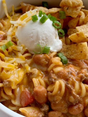 Ground Beef Chili is a fun variation to classic chili! Loaded with beef, seasonings, tomatoes, pinto beans, and tender pasta. Best part is the homemade queso sauce in the ground beef chili!