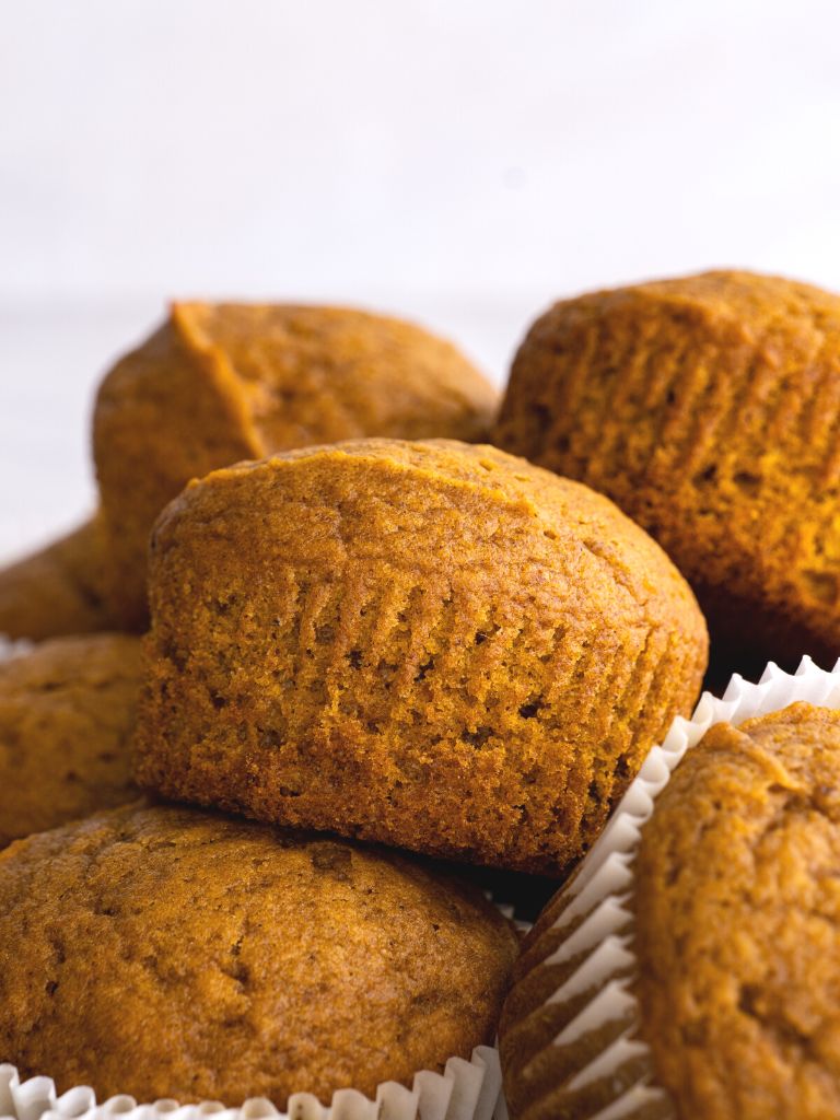 A pile of muffins with pumpkin and spices in them. Close up to show the detail of the soft muffin. 
