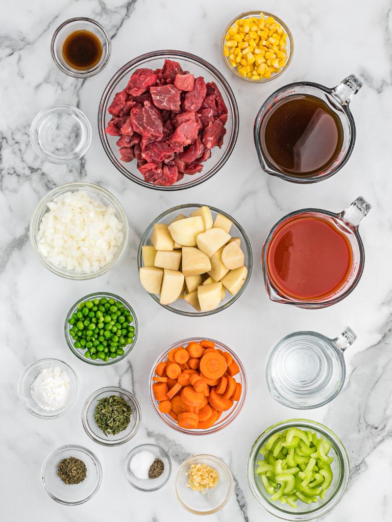 Ingredients needed for this beef stew recipe laid on a white background. 