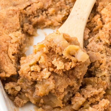 Pan of apple cobbler with a wooden serving spoon in it