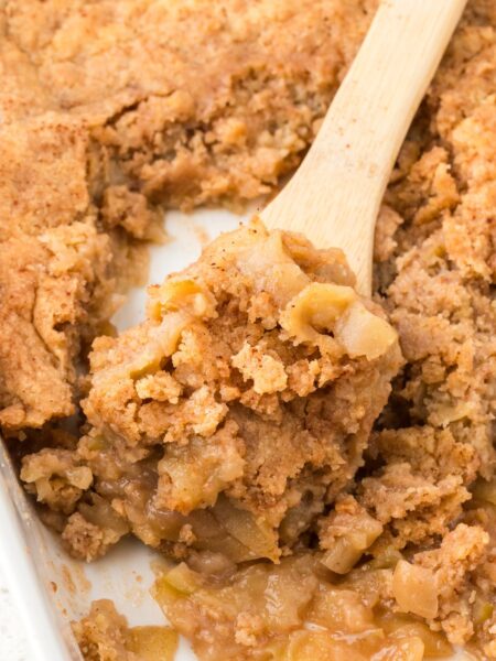 Pan of apple cobbler with a wooden serving spoon in it