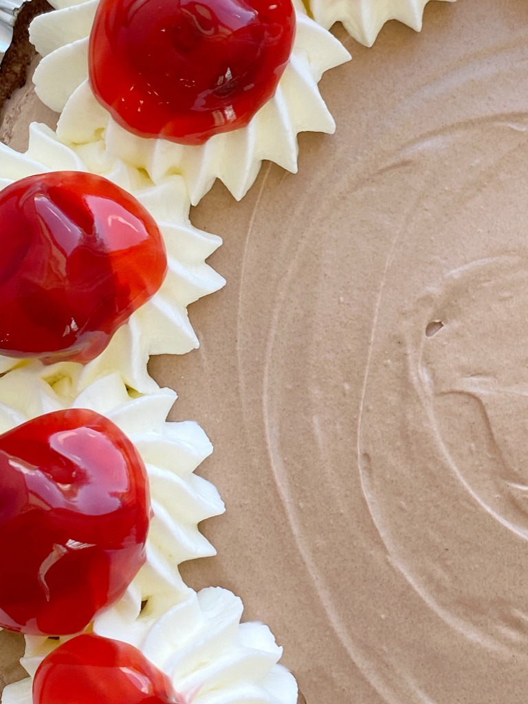 No Bake Black Forest Pie has a chocolate cookie crust with two layers of smooth cheesecake. Top with a spoonful of canned cherry pie filling. 