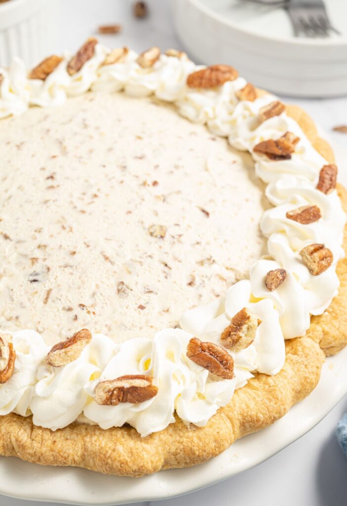 Whole pie topped with whipped cream and pecans