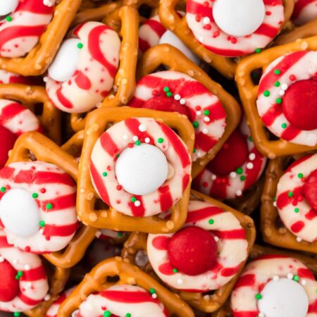 Top view of a bowl of pretzel bites with a peppermint candy cane kisses.