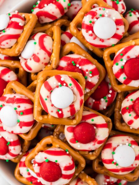 Top view of a bowl of pretzel bites with a peppermint candy cane kisses.