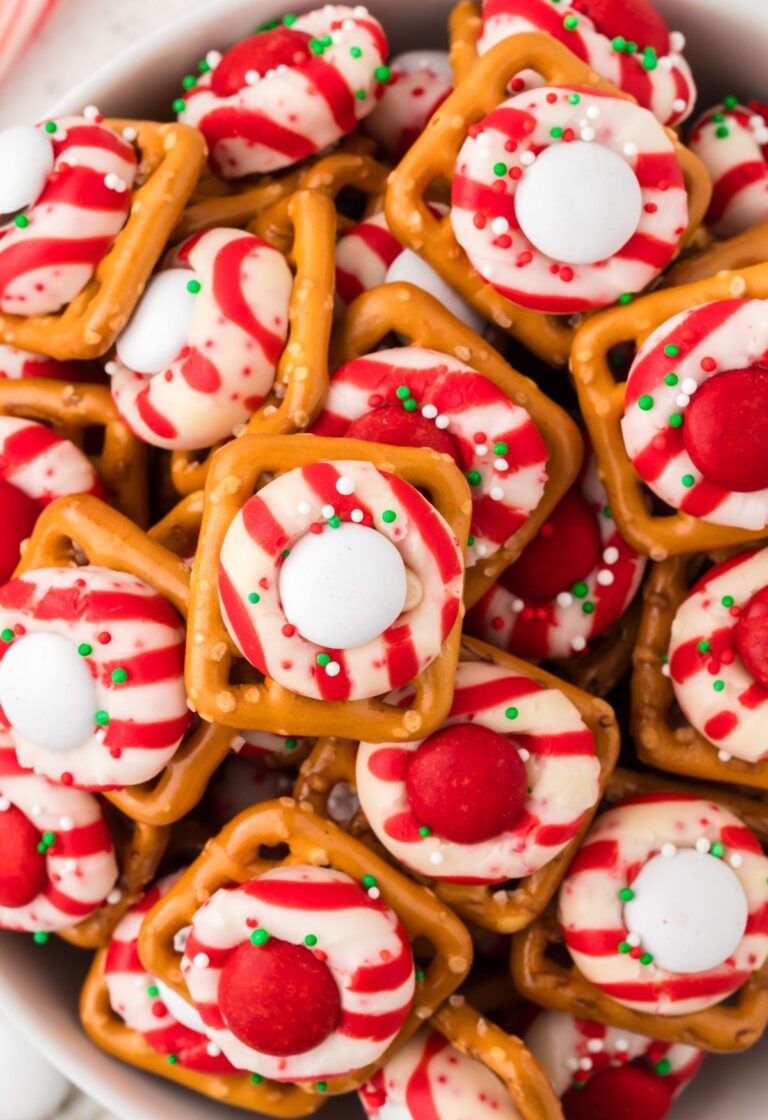 Top view of a bowl of pretzel bites with a peppermint candy cane kisses.