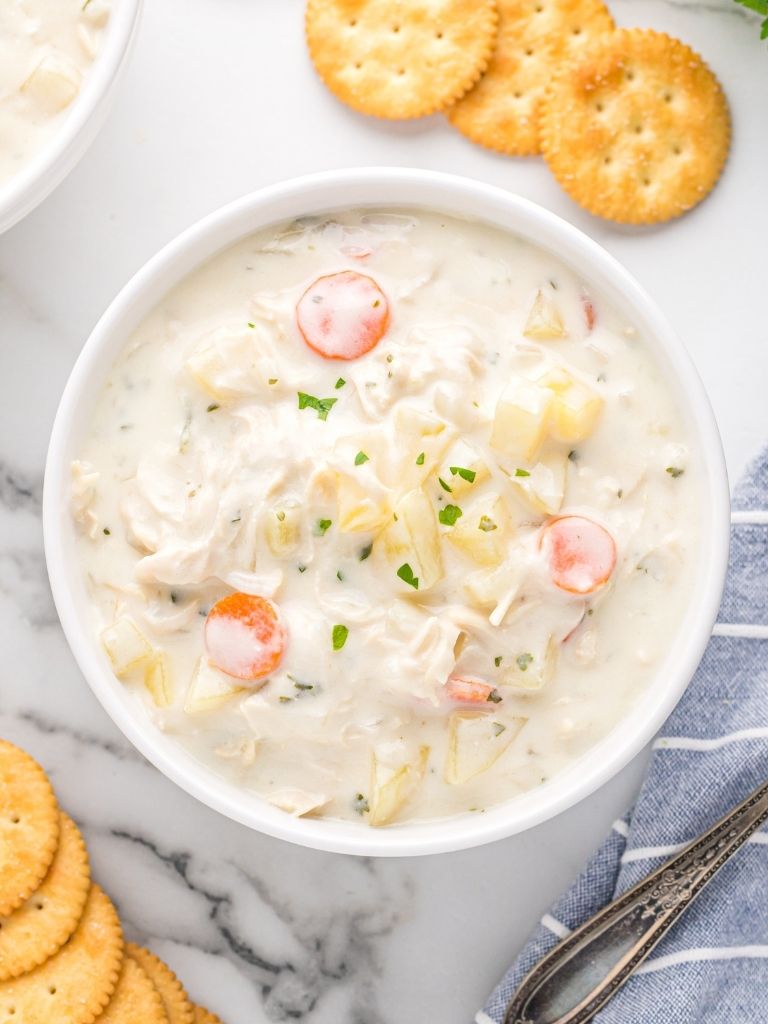 Overhead shot of a bowl of soup with crackers on the edges. 